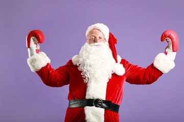 Funny drunk Santa Claus in boxing gloves on color background