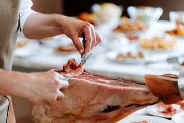 Chef cut a slice of traditional spanish jamon