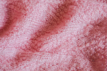 Pink knitted background. Close up gray fabric texture background. wrinkled and shadows, selective focus top view