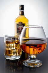 ST. PETERSBURG, RUSSIA - September 09, 2019: Bottle of whiskey and two filled whiskey with ice on a white background