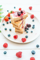 Slice of classic cheesecake with fresh berries on the white plate - healthy organic summer dessert.