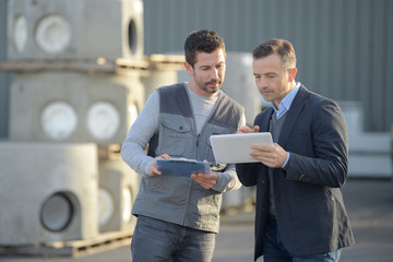 man using phone outside a factory