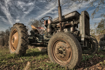 Old rusty tractor in a field on a sunny day
