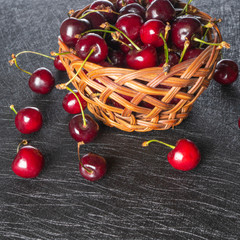 Basket with fresh cherries on a dark background - 309851071