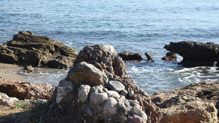 Fototapeta na wymiar Felsen und Steine vor phantom blauen Meereshintergrund