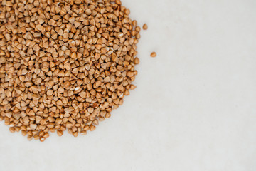 Handful of buckwheat on a white background close-up