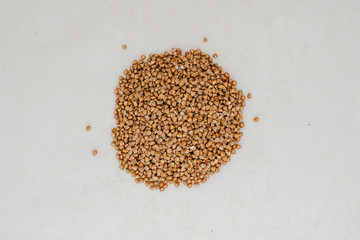 Handful of buckwheat on a white background close-up
