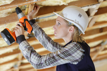serious female builder with drill tool