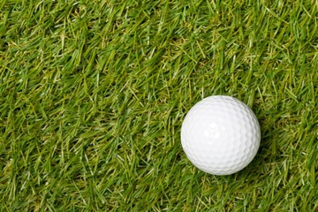 White golf ball on green grass lawn with copy space top view flat lay from above with copy space