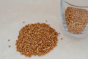 Handful of buckwheat on a white background close-up