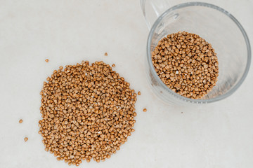 Handful of buckwheat on a white background close-up