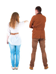 Back view of a stylish couple pointing.