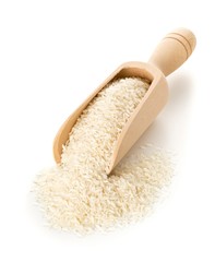 Heap of white uncooked, raw long grain rice in wooden scoop on white