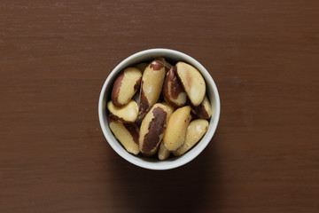 Brazilian nuts in a bowl on a wooden table. Kitchen background.