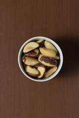 Brazilian nuts in a bowl on a wooden table. Kitchen background.
