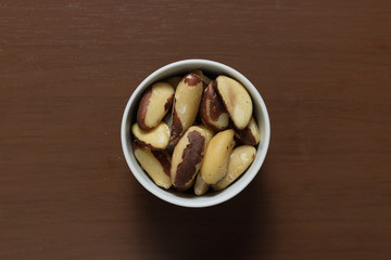 Brazilian nuts in a bowl on a wooden table. Kitchen background.