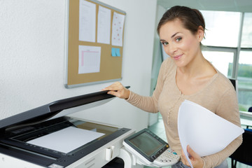 woman smiling makes photocopies in office