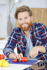 chef slicing tomatoes in a ray of sunlight