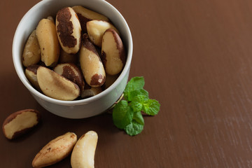 Brazilian nuts in a bowl on a wooden table. Kitchen background.