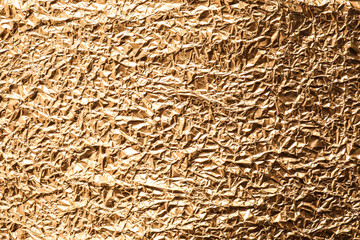 Crumpled gold foil as background, top view