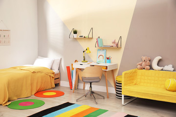 Stylish child room interior with comfortable bed and desk