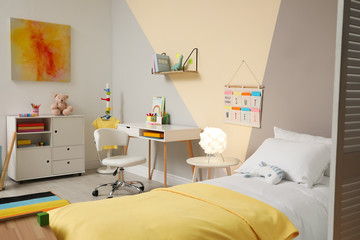 Stylish child room interior with comfortable bed and desk