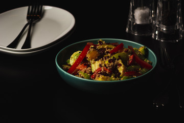 Healthy vegetarian salad with quinoa, bell pepper and avocado, black background space for text