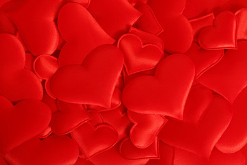 Red fabric hearts arranged randomly. Background