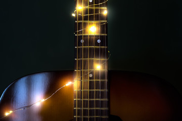 Guitar with Christmas lights with a soft focused decorated Christmas Tree in the background