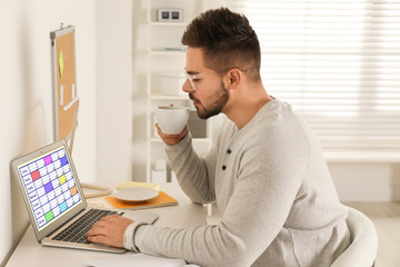 Young man using calendar app on laptop in office
