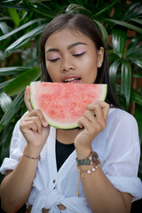 Asian girl portrait with watermelon slice fruit. Beautiful Balinese women. Beauty salon, fresh, summer concept