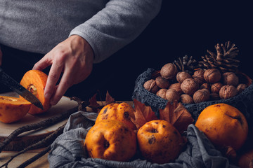 Still life of Man with black apron cutting a quince