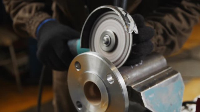 employee grinds flange detail of pumping system at plant