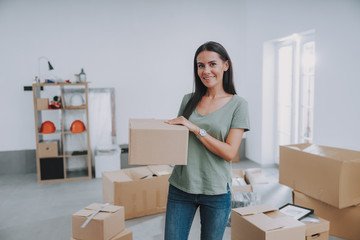 Smiling pretty woman standing in her new flat