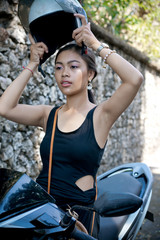 Fototapeta premium Asian girl; in a black dress on a scooter. Beautiful Balinese women lifestyle portrait