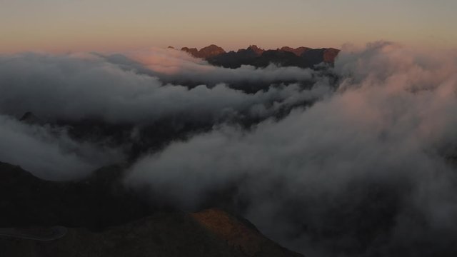 Flying over dreamy misty landscape. Aerial view of the mountains during epic sunset. 