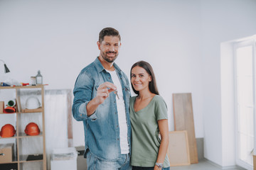 Happy man and woman with key in new home