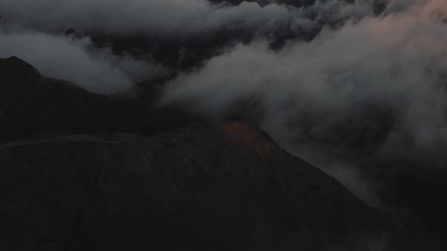 Dramatic dark aerial scene of misty sunset over the mountains. 