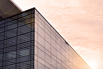 Sun rays light effects on urban buildings. Abstract image of looking up at modern glass and concrete building. Architectural exterior detail of office building.