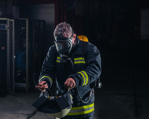Obraz premium Firefighter with protective uniform wearing oxygen mask
