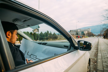 Thieves parked in an ally waiting while observing their target and loading their guns.