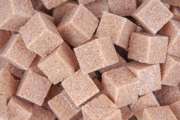 Cane sugar cubes background top view texture