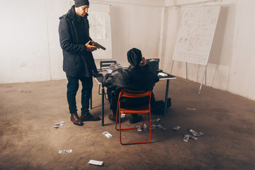 Adult robbers arguing with pointed gun