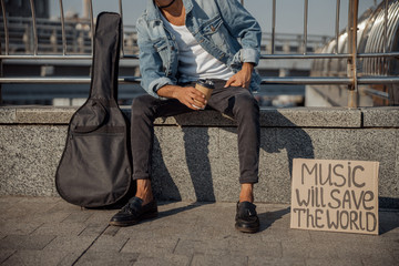 Guitarist holding hot drink on the street