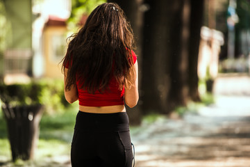Female legs riding roller skates. Back view