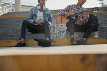 Two musicians collecting money in a black hat