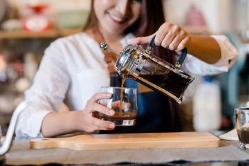 Professional Asian woman Barista preparing coffee at front counter serving coffee cup to customer occupation, part-time,job or owner business working woman happy selling and making drink beverage