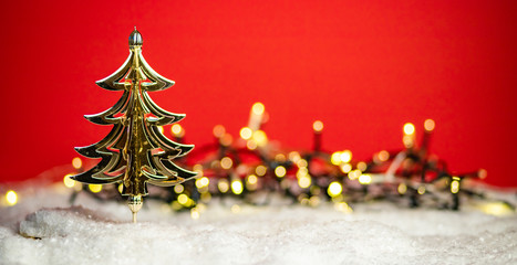 shiny golden Christmas tree on red background