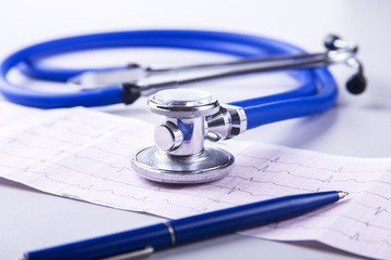 Medical stethoscope lying on cardiogram chart closeup. Medical help, prophylaxis, disease...