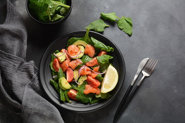 Mediterranean Avocado Salmon Salad with spinach, cherry tomatoes, avocado and red onion dressing. Concept for a tasty and healthy meal. Vegan food